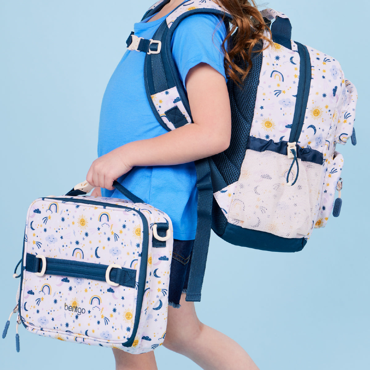 Person wearing a blue shirt and carrying a matching backpack with a colorful pattern on a light blue background