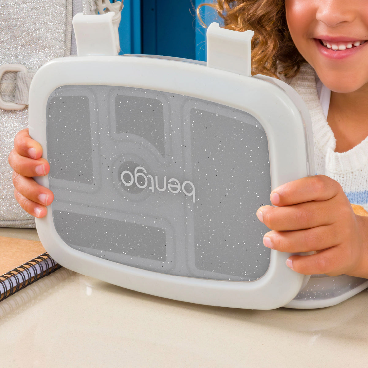 Child holding a Bentgo lunch box with a focus on the brand name.