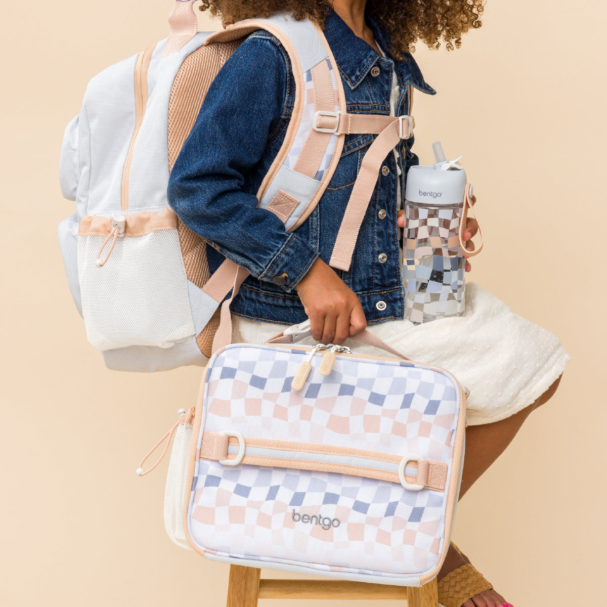 Person holding a patterned bag with a beige background